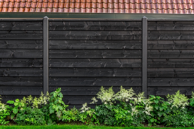 Zwart gespoten hout-betonschutting