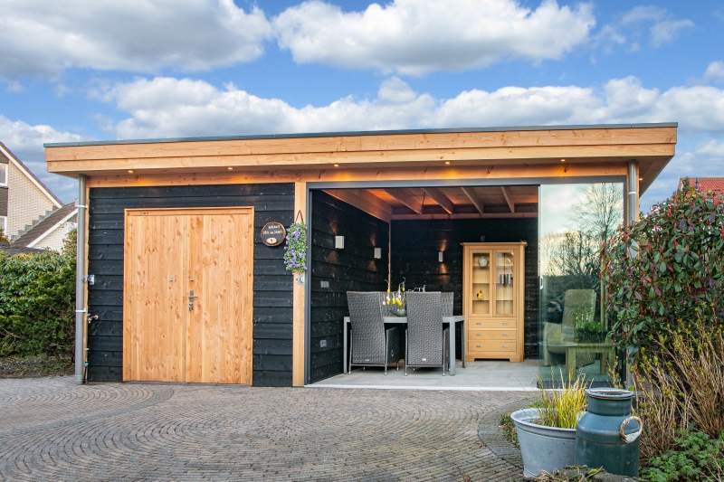 Zwart houten tuinhuis met overkapping